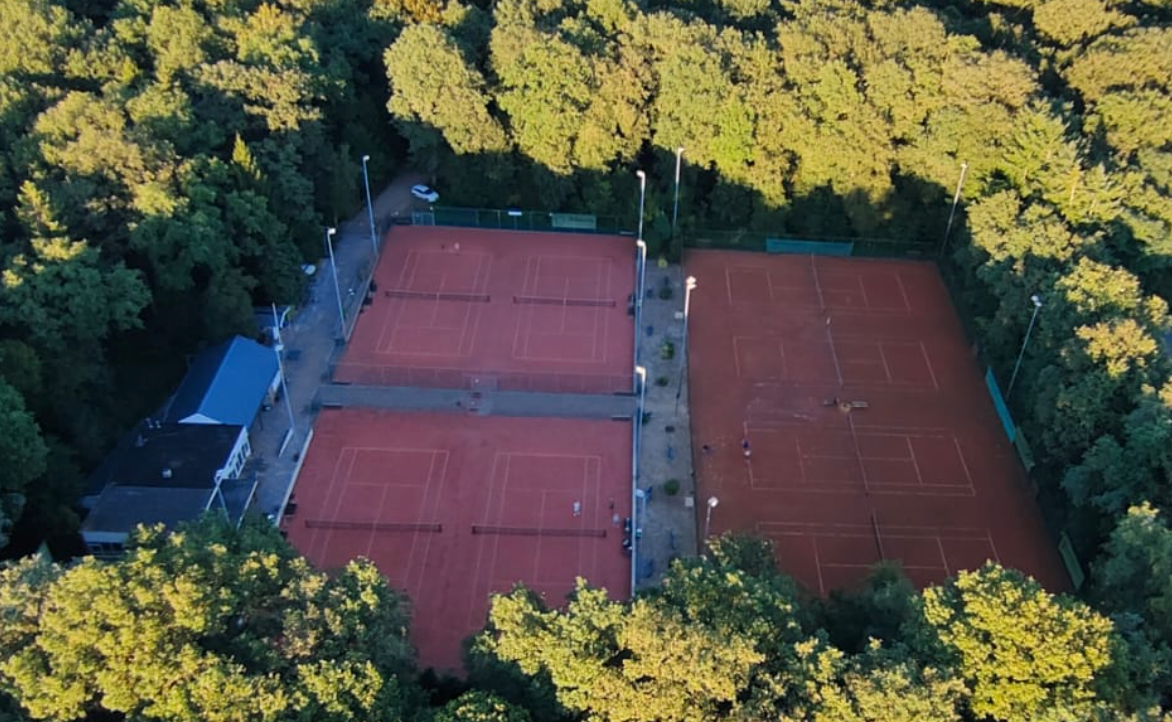 De tennisbanen van HLTC Spaarbankbos, omgeven door bomen